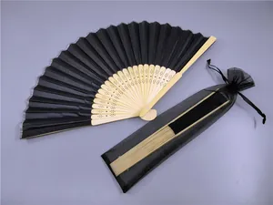 Detalle de un abanico plegable negro con bolsa de regalo de organza negra a juego incluida