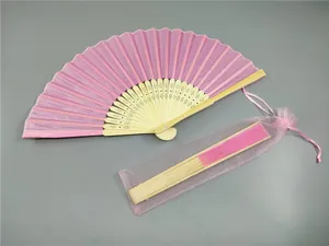 Vista detallada de un abanico plegable rosa de bambú con bolsa de regalo de organza a juego.