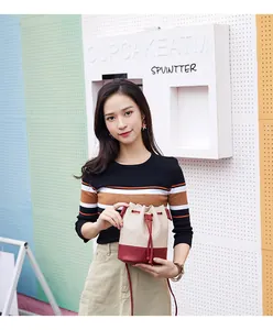 Stylish color-block drawstring bucket bag with lattice texture held by a female model