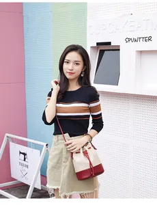 Fashionable Asian model showcasing a color-block quilted drawstring bucket bag outdoors
