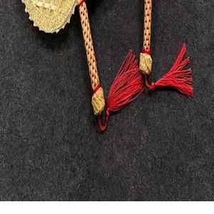 Close-up detail of a traditional handwoven natural cattail fan featuring vibrant red tassels