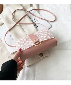 Close-up of pink crossbody bag with lace flower embroidery detailing