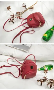 Close-up details of mini red backpack with metal rabbit ear design