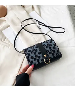 Detailed view of small floral square crossbody shoulder bag with gold ring hardware