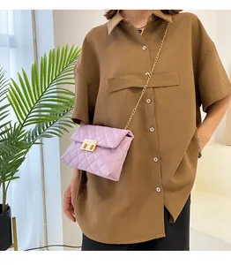 Close-up of a stylish purple quilted crossbody bag with a gold chain strap