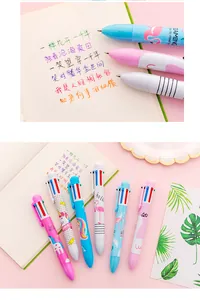Multi-color ballpoint pens with cartoon unicorn and flamingo patterns on a notebook