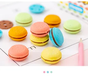Detailansicht bunter Radiergummis in Macaron-Form auf einem Schreibtisch mit Bleistift.