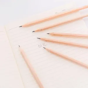 Natural wood HB pencils scattered on a minimalist cream lined notebook background
