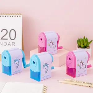 Set di simpatici temperamatite manuali con unicorno rosa e delfino blu sulla scrivania