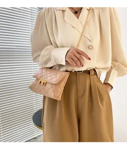 Elegant beige quilted chain crossbody square bag with gold turn-lock worn by a model