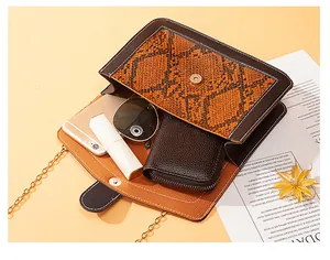 Close-up of snakeskin pattern crossbody bag showing internal storage capacity