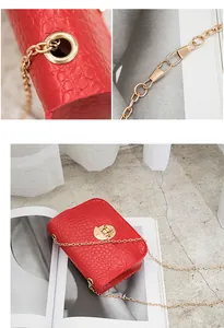 Vista dettagliata di una borsa rossa a tracolla con motivo a pietra e catena oro.