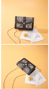 Elegant snake skin pattern chain square bag with gold clasp shown on warm background