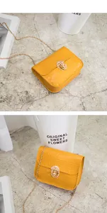 Dettaglio borsa quadrata gialla motivo coccodrillo con chiusura e tracolla catena.