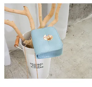 Dettaglio borsa a tracolla azzurra con stampa cocco e chiusura dorata