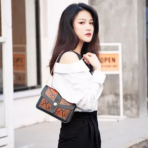 Stylish snakeskin pattern chain crossbody bag with color-blocking design on a fashion model