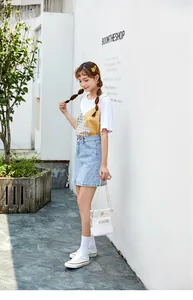 Asiatisches Modell mit einer transparenten Umhängetasche mit Gänseblümchen-Print