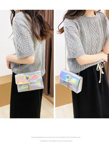 Close-up detail of a holographic silver crossbody bag with flower clasp and tassel on a model