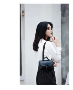 Elegant model styling a black crocodile pattern chain crossbody bag with white shirt