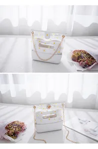 Detailansicht der weißen transparenten Tasche mit Gänseblümchendruck, Goldkette und Innentasche