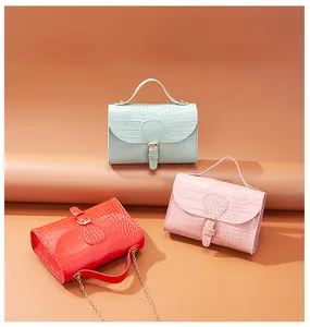 Three elegant croc-embossed small square flap handbags in mint, pink, and red colors.
