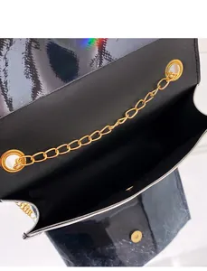 Detailed macro view of a black holographic small square bag with gold chain strap