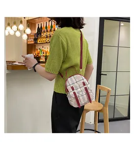 Back view of a model wearing a plaid mini backpack with red straps in a bar setting