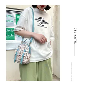 Model wearing a plaid mini crossbody bag with light blue straps for a casual look.