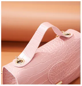 Close-up of pink stone pattern handbag featuring gold-tone hardware eyelets.