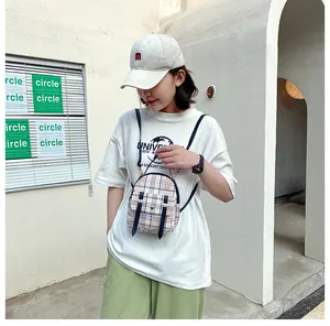 Woman wearing a stylish mini plaid crossbody backpack in an outdoor urban setting