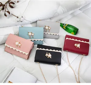 Detailed view of small crossbody bags with cat pearl accents in five colors.