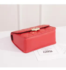 Vista dettagliata di una borsa a tracolla trapuntata rossa con chiusura dorata.
