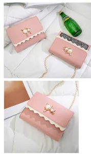 Detailed view of minimalist pink chain bag with scalloped edges and cat pearl decoration