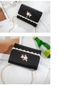 Elegant black chain bag with cute cat pearl ornament and scalloped edge detail.