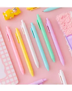 Detailed macro view of vibrant macaron colored retractable gel pens on pink background