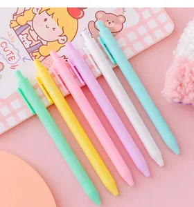 Close-up detail of six pastel macaron colored retractable gel pens on a pink desk