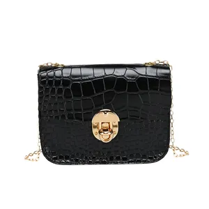 Elegante borsa a tracolla nera con motivo a pietra, catena dorata e chiusura chic