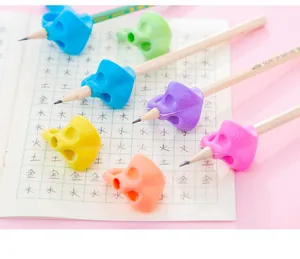 Colorful ergonomic writing posture correction pencil grips for children on paper