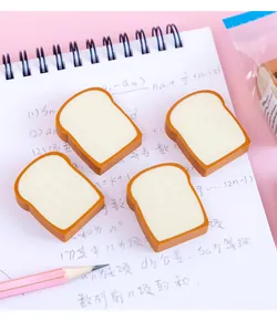 Detailaufnahme von niedlichen Radiergummis in Toastform auf einem karierten Schülerheft
