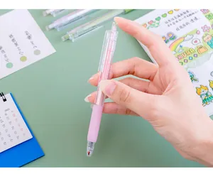 Close-up detail of a pink 0.5mm Macaroon retractable gel pen being held by a hand