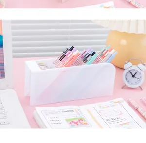 Minimalist frosted white slanted pen holder organizer on a pink desk with office supplies
