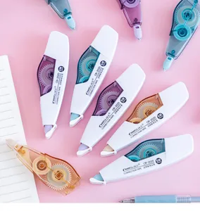 Close-up of Morandi colored pastel correction tapes with clear gears on pink background.