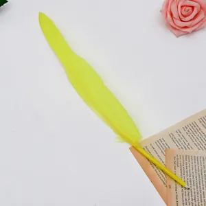 Close-up of a bright yellow feather ballpoint pen on an elegant book page background