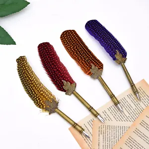Vintage spotted feather dip pens in four colors on antique paper background.