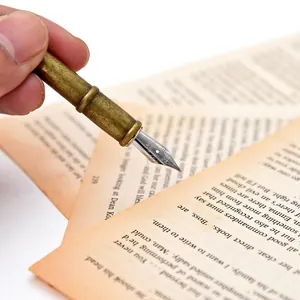 Close-up of vintage brass fountain pen nib and barrel on aged paper background