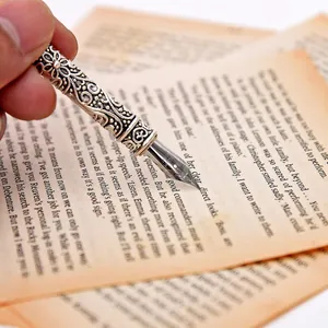 Detailed macro shot of an ornate silver relief fountain pen nib writing on vintage aged paper