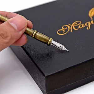 Gros plan détaillé d'une plume de stylo-plume en laiton vintage sur un coffret cadeau noir.