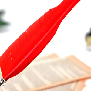 Gros plan d'une plume d'oie rouge vif avec connecteur en métal gravé de style rétro