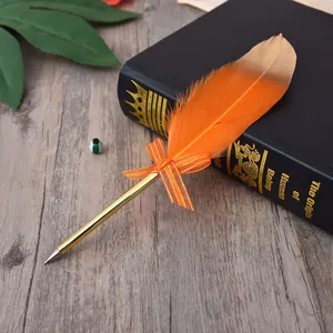 Detailed view of an elegant orange feather ballpoint pen with a gold barrel and bow