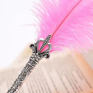 Detailed macro view of a vintage pink feather quill pen with an ornate silver metal handle